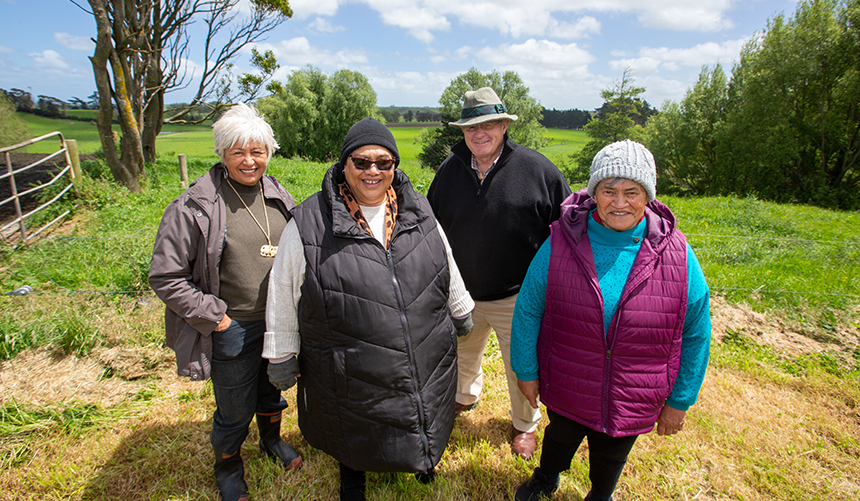 4 people standing outside in a field.